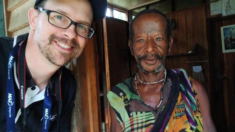 Two men standing in doorway of hut