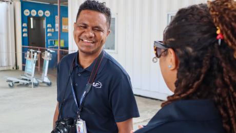 A man smiling next to another person