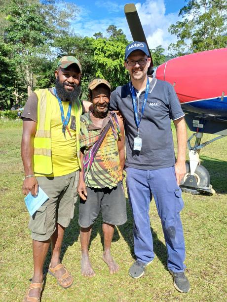 Three men standing in front of Cessna Caravan