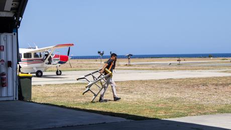 A man carries a ladder at an airport