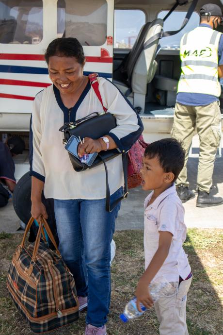 A mother and child disembark from a plane