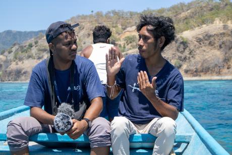 A man interviews a man on a boat