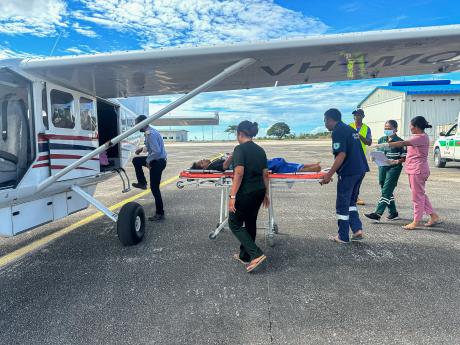 A stretcher patient is loaded onto small plane