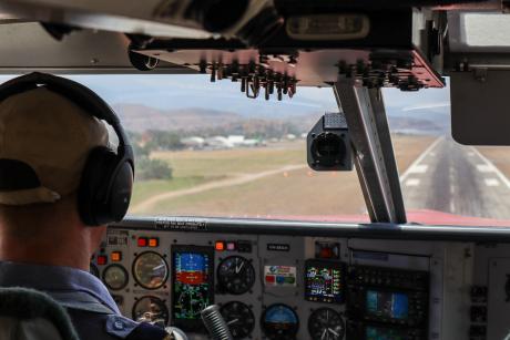 An in-cockpit view of a pilot landing on a runway